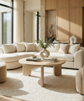 Modern living room with beige sofa, wooden coffee table, and decorative items.