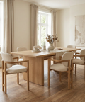 Dining room with wooden table and chairs in a bright room.