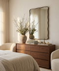 Wooden dresser with decorative items in a bedroom setting