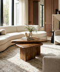 Modern living room with a wooden coffee table, white sofa, and fireplace.