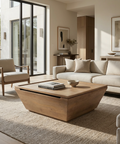 Modern living room with a wooden coffee table, beige sofa, and armchair.