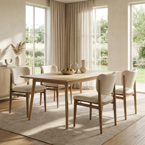 Dining room with wooden table and chairs in a bright room with large windows.