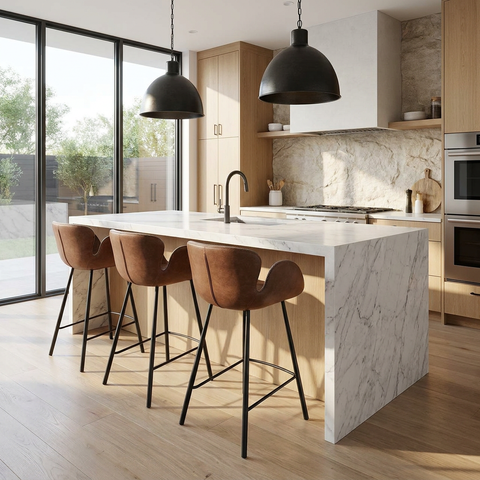Modern kitchen with marble island, bar stools, and stainless steel appliances.