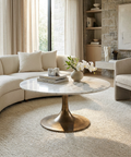 Modern living room with a marble coffee table, beige sofa, and armchair.