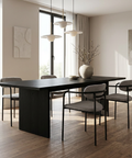Modern dining room with a black table and gray chairs in a bright room.