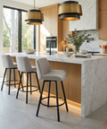 Modern kitchen with marble island, bar stools, and pendant lights.