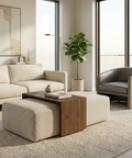 Modern living room with beige sofa, ottoman, and armchair near large windows.