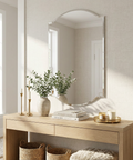 Wooden console table with decorative items in a room with a large mirror.