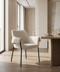 Modern dining room with a chair and table near large windows.