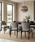 Dining room with a dark wooden table and gray chairs in a modern interior setting.