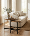 Cozy living room with a beige sofa, wooden side tables, and decorative elements.