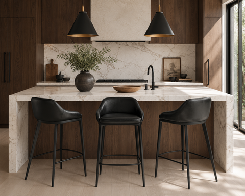 Modern kitchen with marble island, black bar stools, and pendant lights.