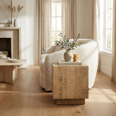 Modern living room with a white sofa, wooden side table, and decorative items.