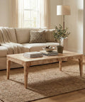 Living room with beige sectional sofa, wooden coffee table, and decorative items.
