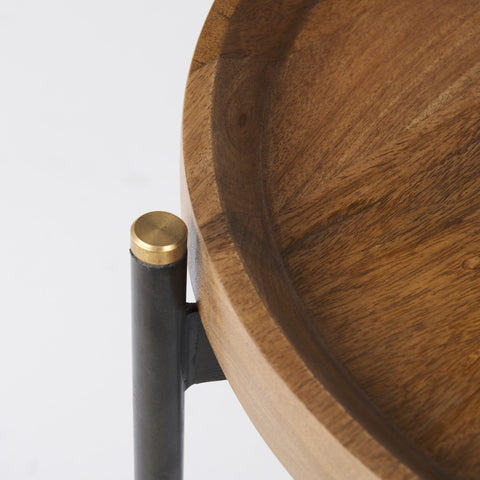 Wooden table with a black metal leg and gold accent on a white background