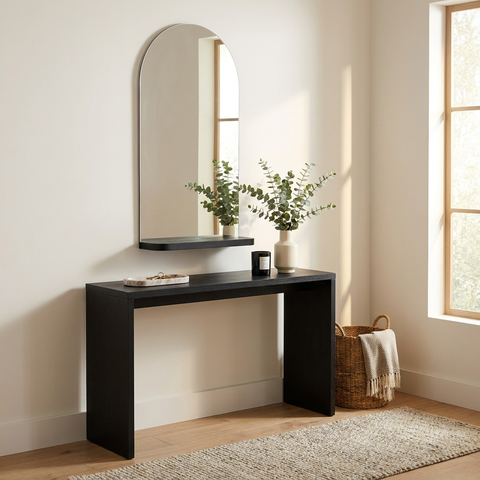 Black console table with mirror and decorative items in a room with a window and rug.
