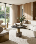 Modern living room with white sofa, round coffee table, and large windows.