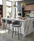 Modern kitchen with marble island, bar stools, and stainless steel appliances.