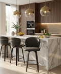 Modern kitchen with marble island, bar stools, and pendant lights.