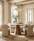 Dining room with a wooden table and beige chairs, featuring a large window and neutral decor.