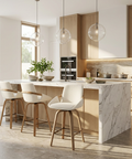 Modern kitchen with marble island, wooden chairs, and pendant lights.