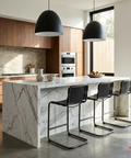 Modern kitchen with marble island and black bar stools