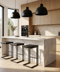 Modern kitchen with marble island, black stools, and pendant lights.