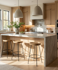 Modern kitchen with marble island, wooden stools, and stainless steel appliances.