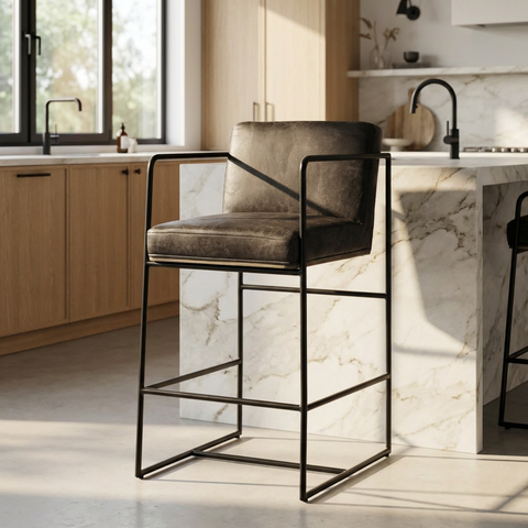 Bar stool with black metal frame and gray cushioned seat in a modern kitchen.