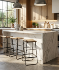Modern kitchen with marble island, wooden stools, and natural light