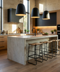 Modern kitchen with marble island, bar stools, and black pendant lights.