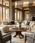 Cozy living room with a stone fireplace, large windows, and comfortable furniture.