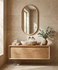 Bathroom with wooden vanity, oval mirror, and plant