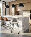 Modern kitchen with marble island, bar stools, and black pendant lights.